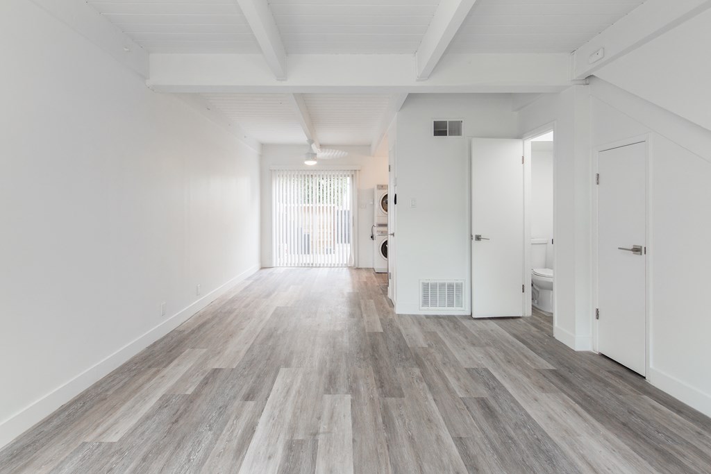 a bedroom with hardwood floors and white walls