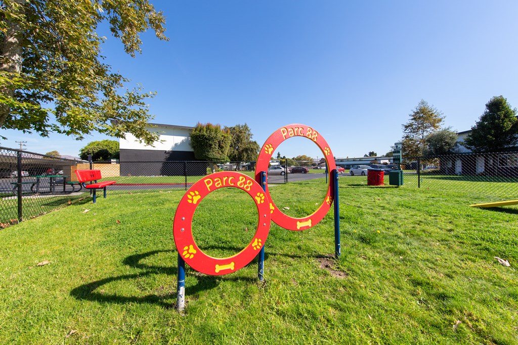 a red and yellow sign in the shape of a olympic rings in a grassy