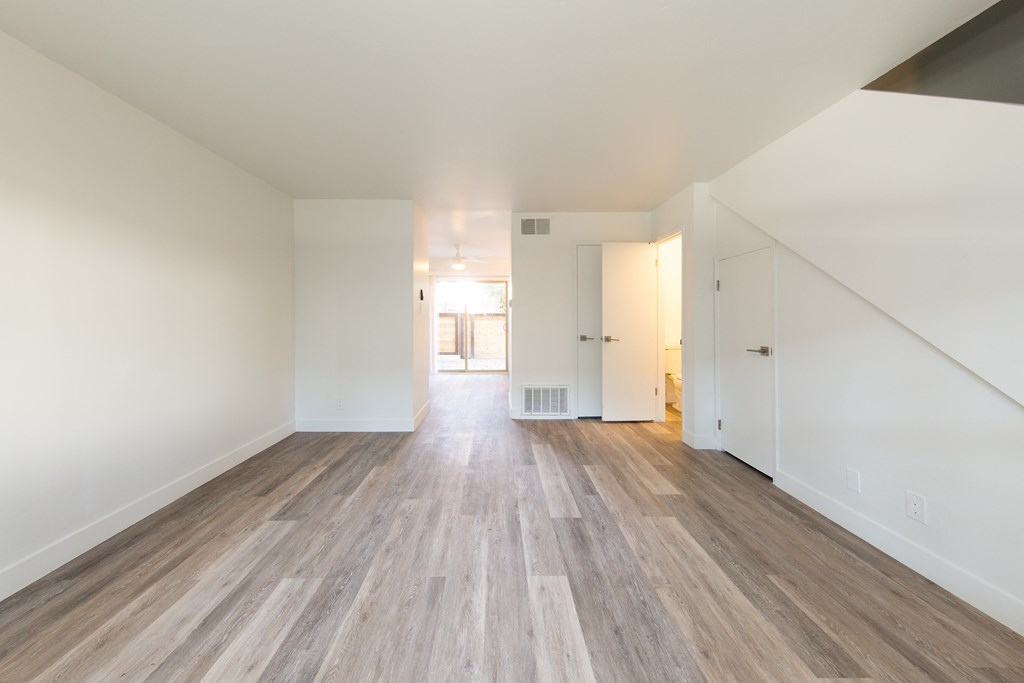 a bedroom with hardwood floors and white walls