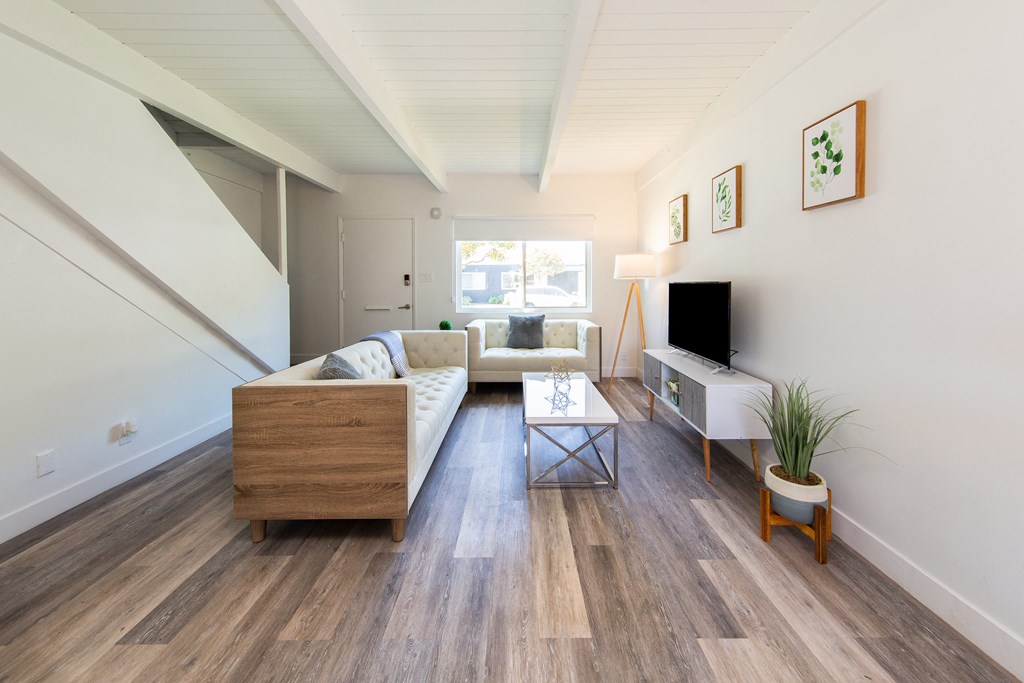 a living room with a white couch and a wooden coffee table