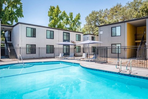 our apartments have a swimming pool with chairs and umbrellas