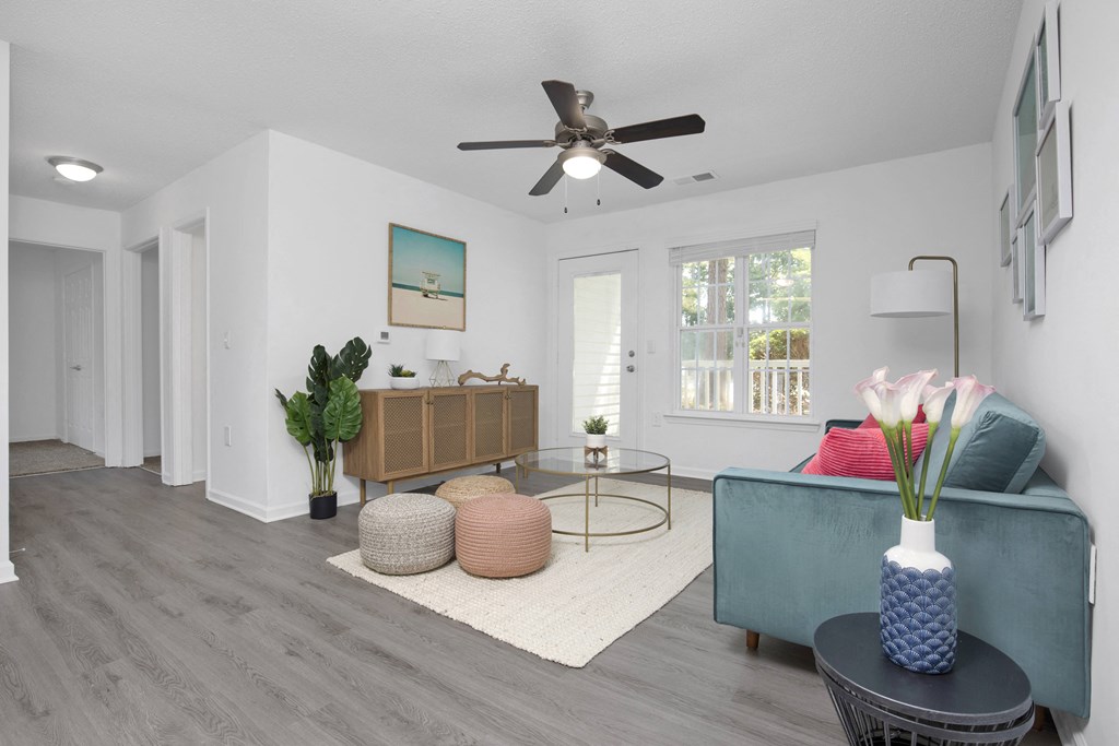 a living room with a blue couch and a ceiling fan