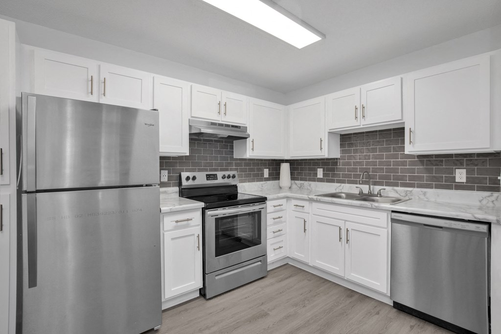 a kitchen with white cabinets and stainless steel appliances