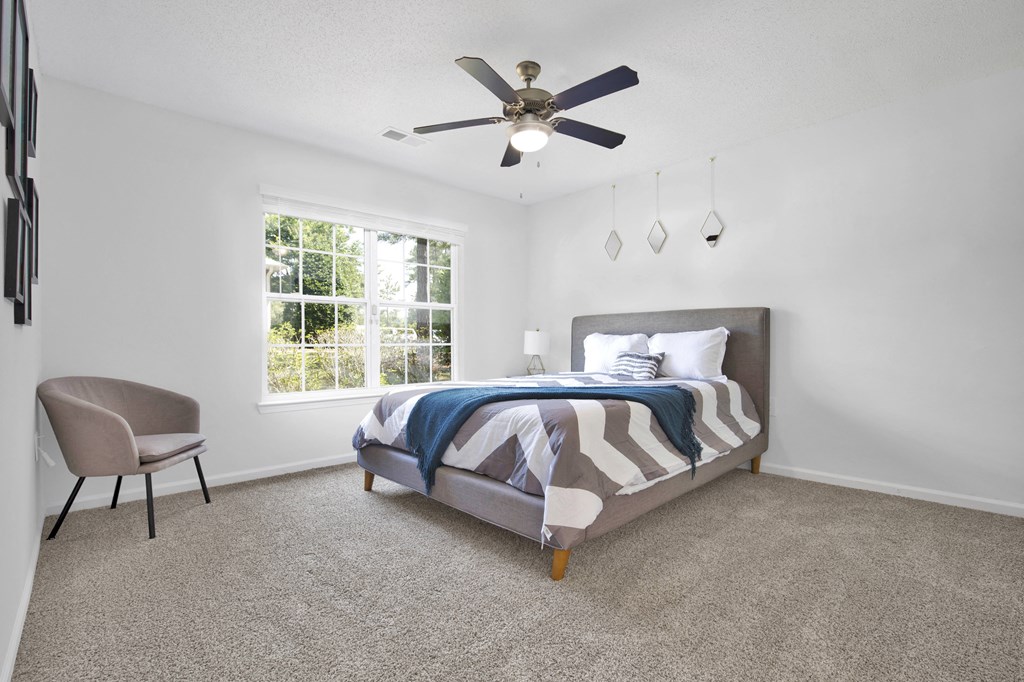 a bedroom with a bed and a ceiling fan