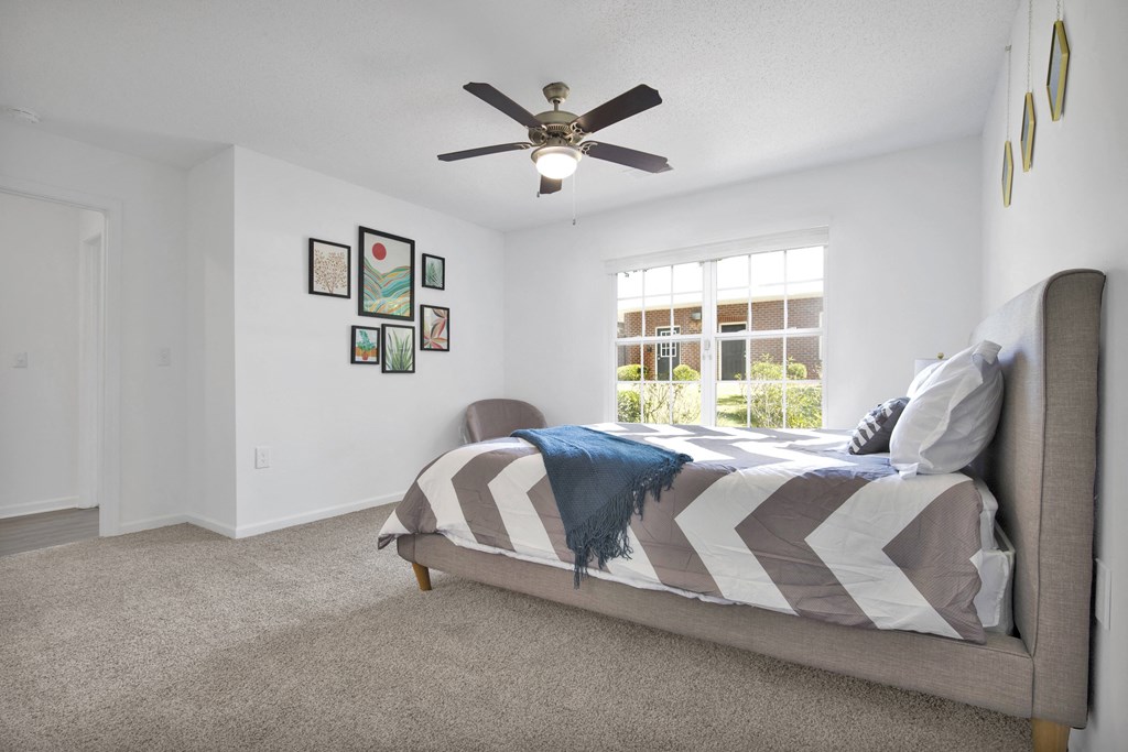 a bedroom with a large bed and a ceiling fan