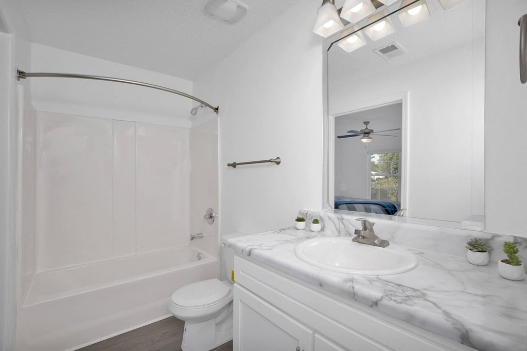 a bathroom with white walls and a white sink and toilet