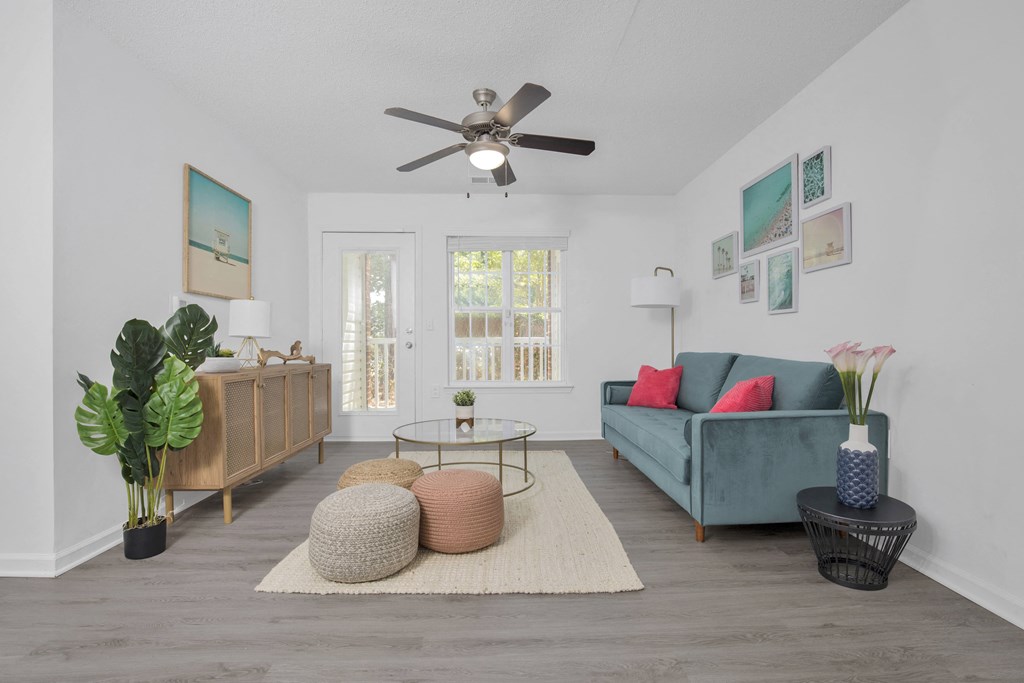 a living room with a blue couch and a ceiling fan