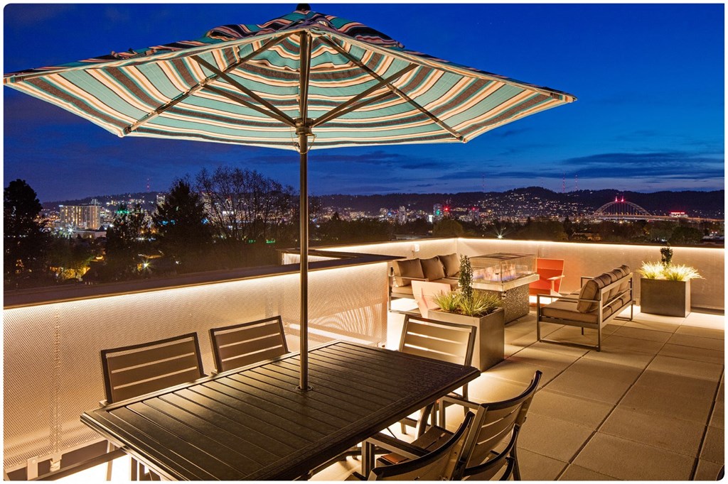 a terrace with a table and chairs under an umbrella