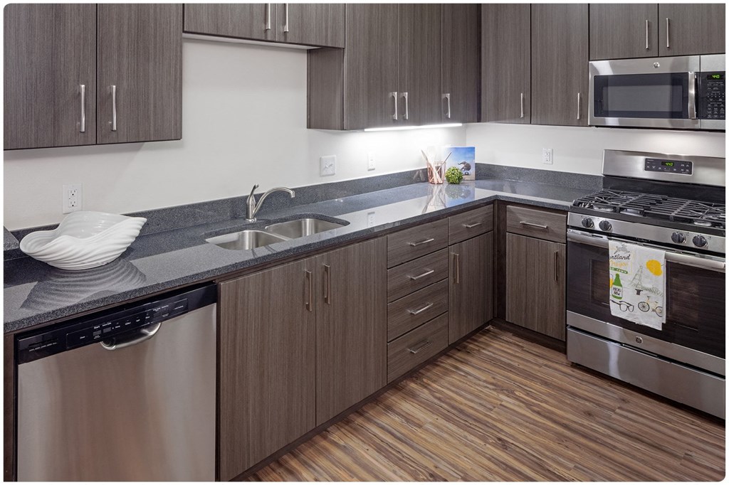 a kitchen with gray countertops and stainless steel appliances