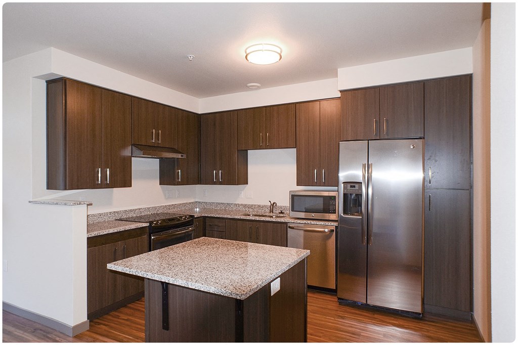 a kitchen with dark wood cabinets and granite countertops