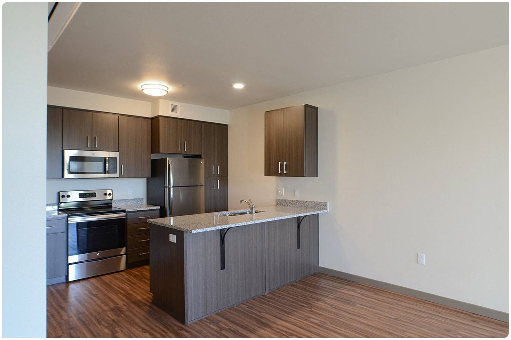 a kitchen with a large island and stainless steel appliances
