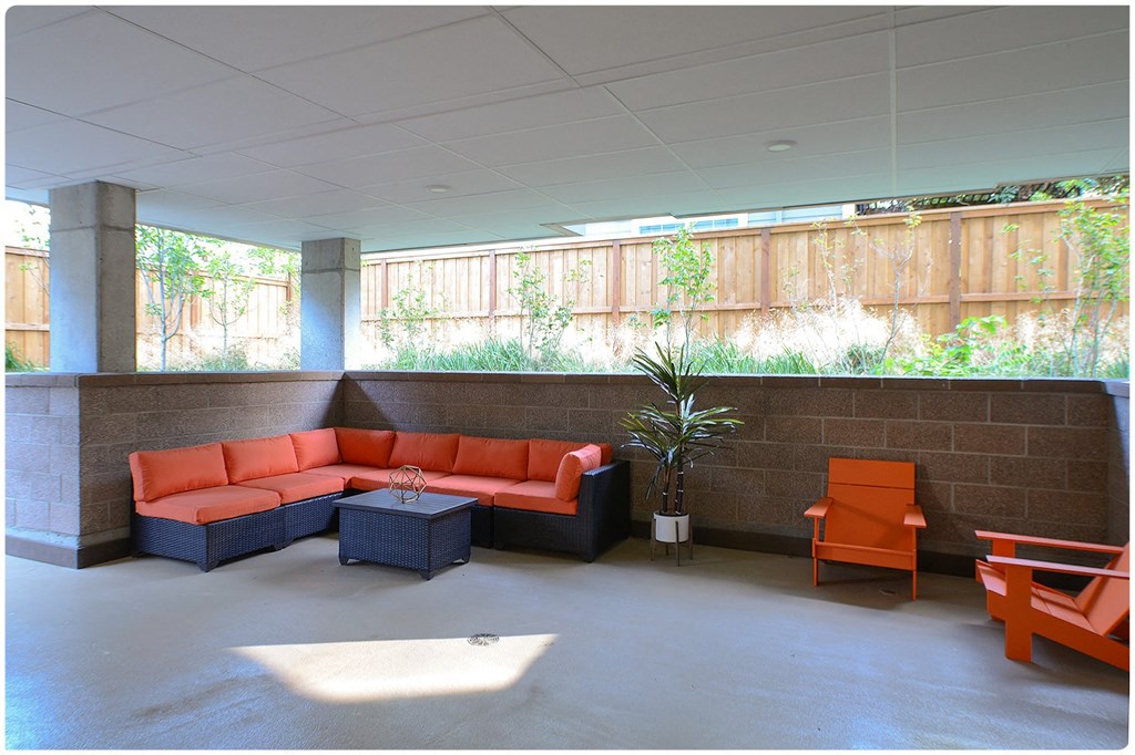 a lounge area with orange chairs and a couch
