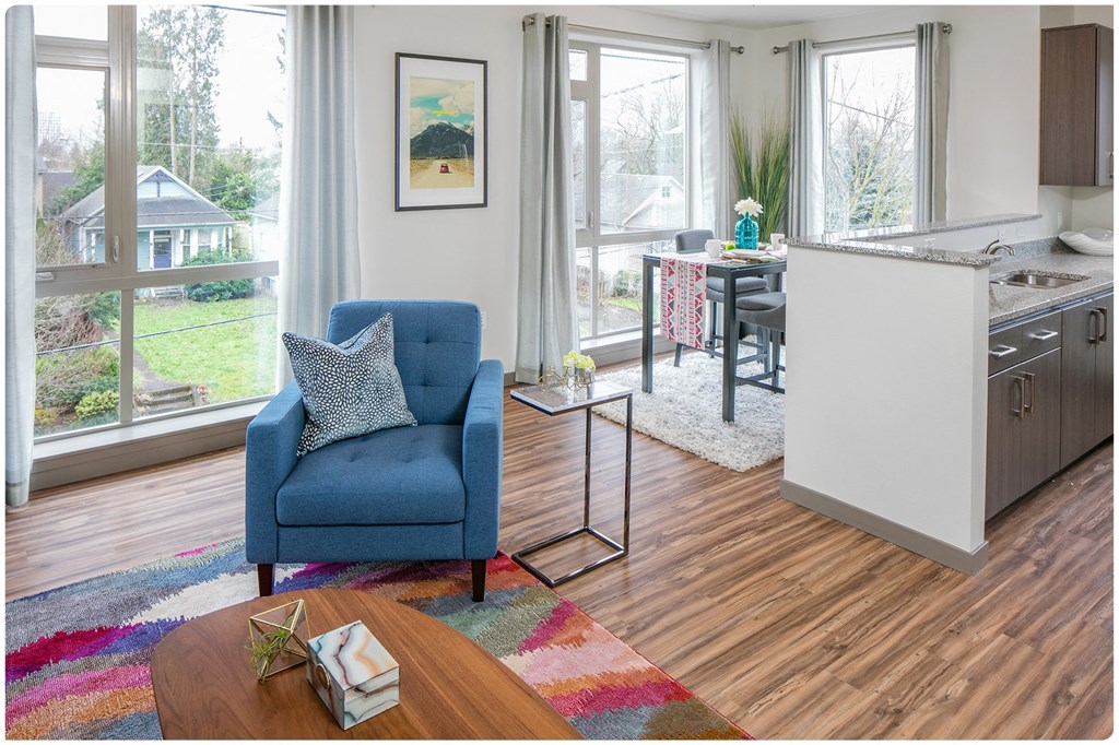 a living room with a blue chair and a colorful rug