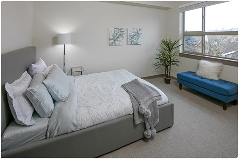 a bedroom with a large bed and a blue chaise lounge