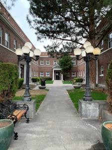 a sidewalk in front of a building with street lights