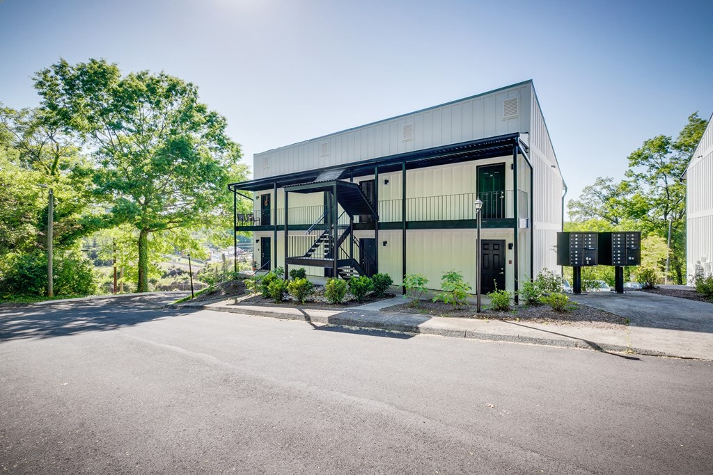 a modern building with a road in front of it and trees