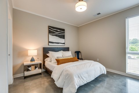 a bedroom with a bed and a nightstand with a lamp