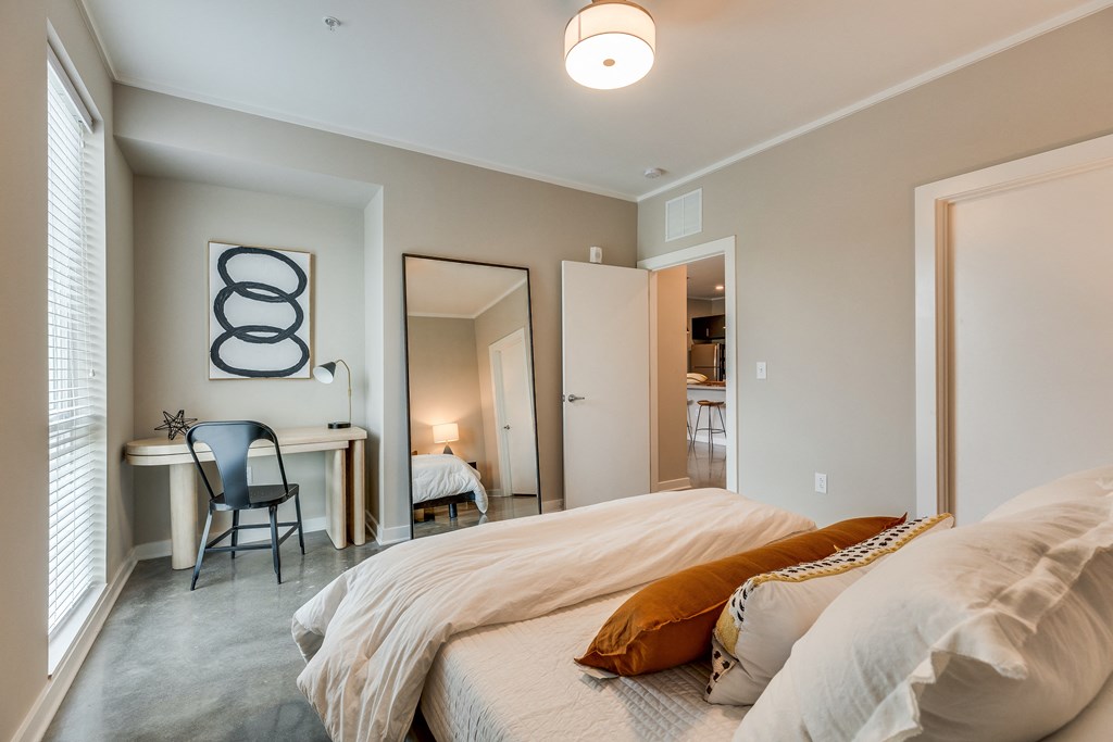 a bedroom with a bed and a desk with a chair