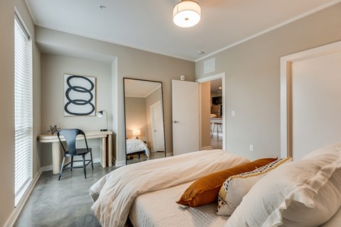 a bedroom with a bed and a desk with a chair