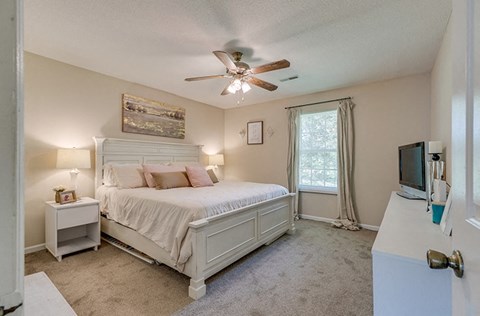 a bedroom with a bed and a ceiling fan