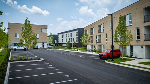 a red truck parked in a parking lot in front of a building