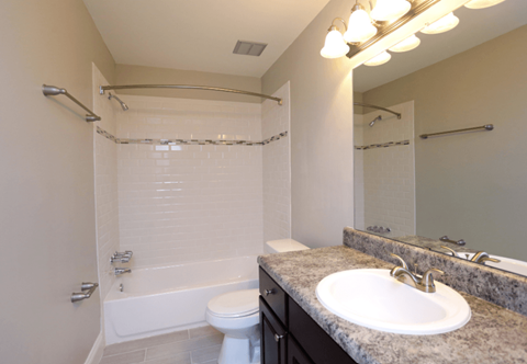 A bathroom with a white toilet, sink, and a shower with a glass door.