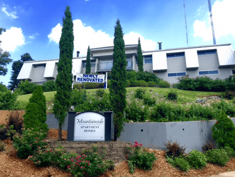 A sign that says "Newly Renovated" is in front of a building.