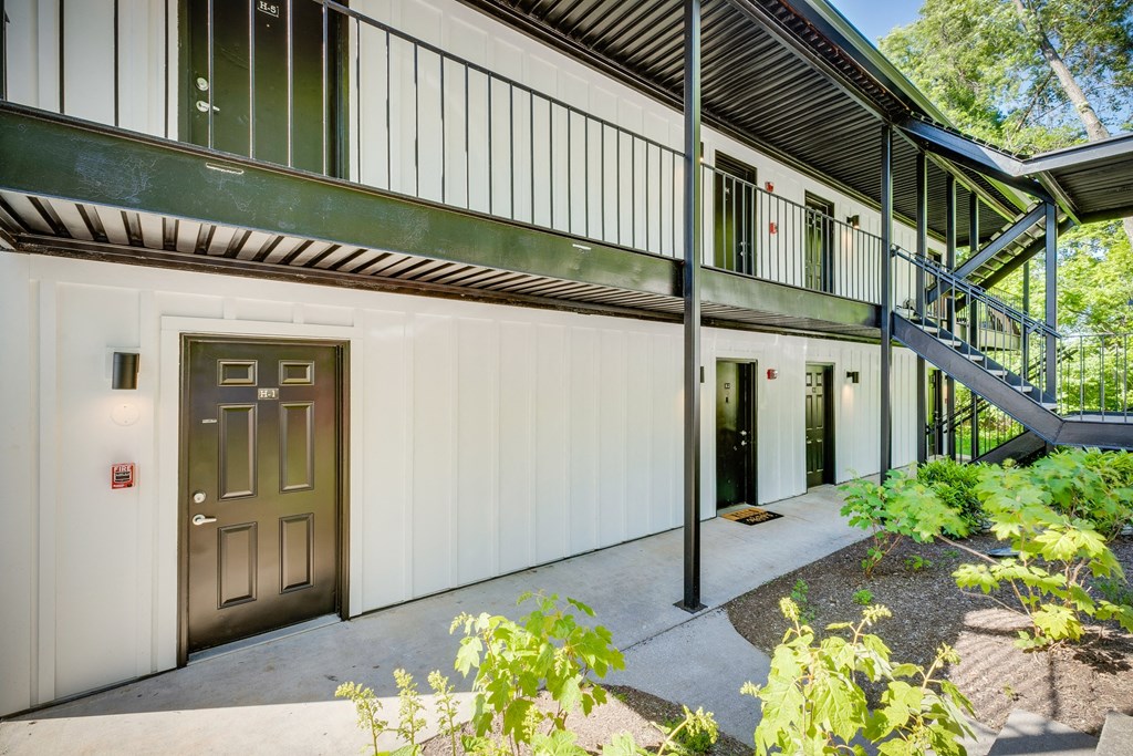 the front door of a white house with a staircase