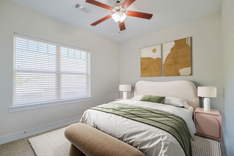 a bedroom with a bed and a ceiling fan