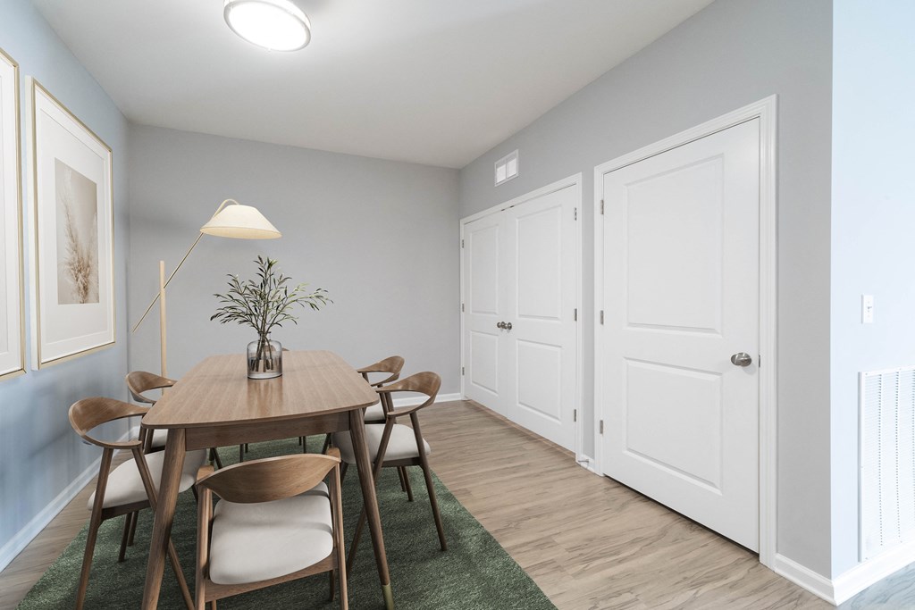 A dining room with a wooden table and chairs.