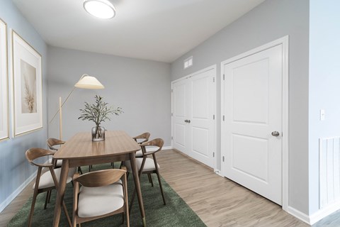 A dining room with a wooden table and chairs.