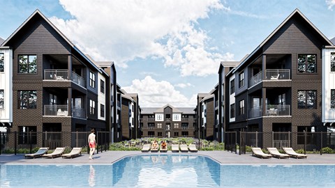 A person is standing by the pool in front of apartment buildings.