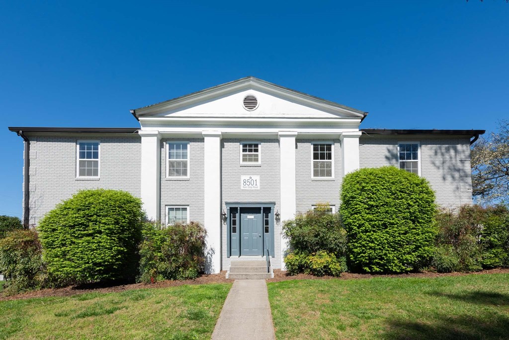 the front of a white house with a blue door