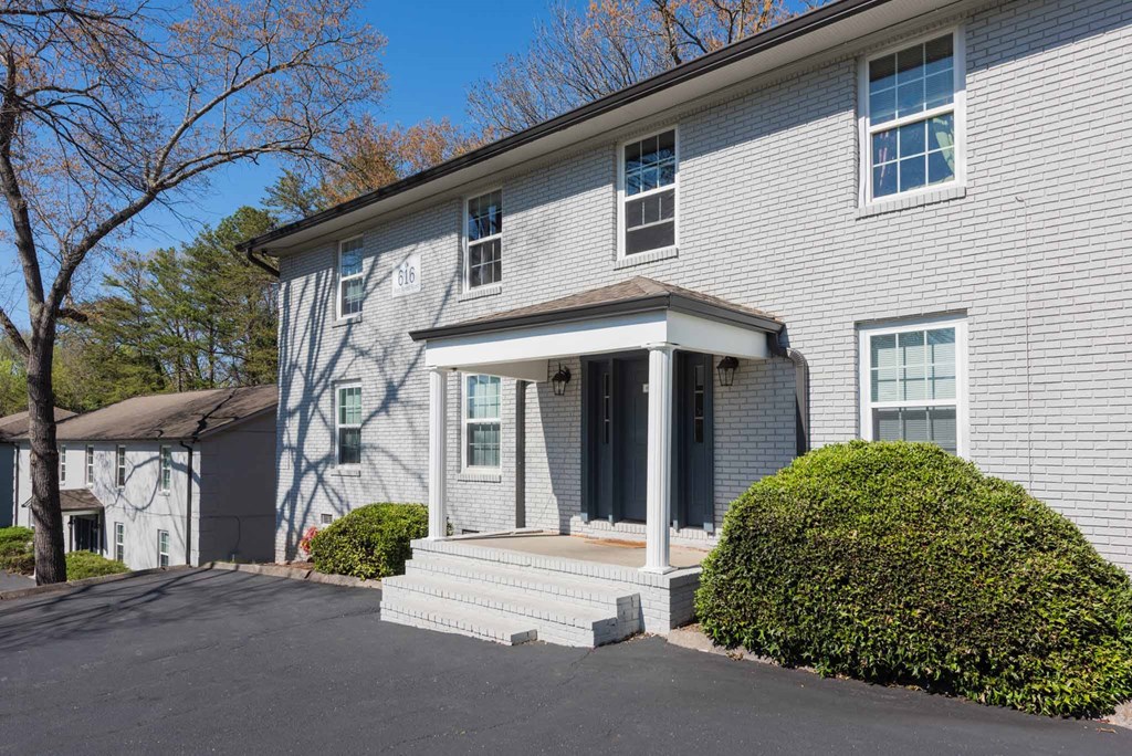 a white house with a front porch and a driveway