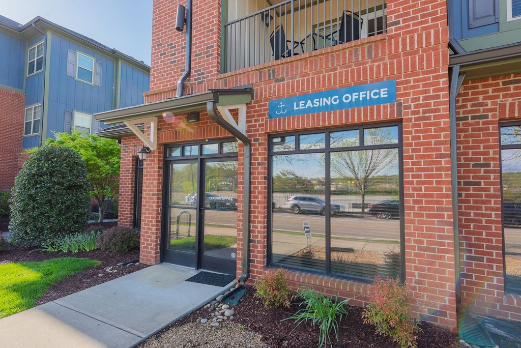 the entrance to the leasing office of a brick building with glass doors