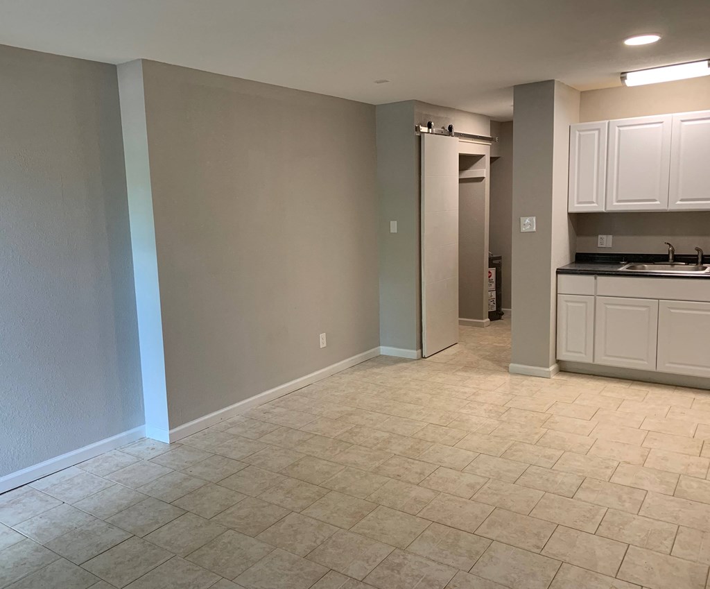 an empty kitchen and living room with a tile floor