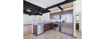A kitchen with a stainless steel refrigerator, oven, and sink.