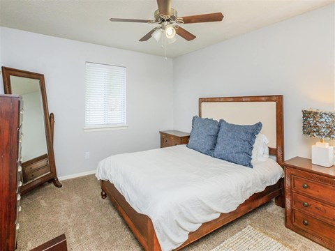 A bedroom with a bed, dresser, and mirror.