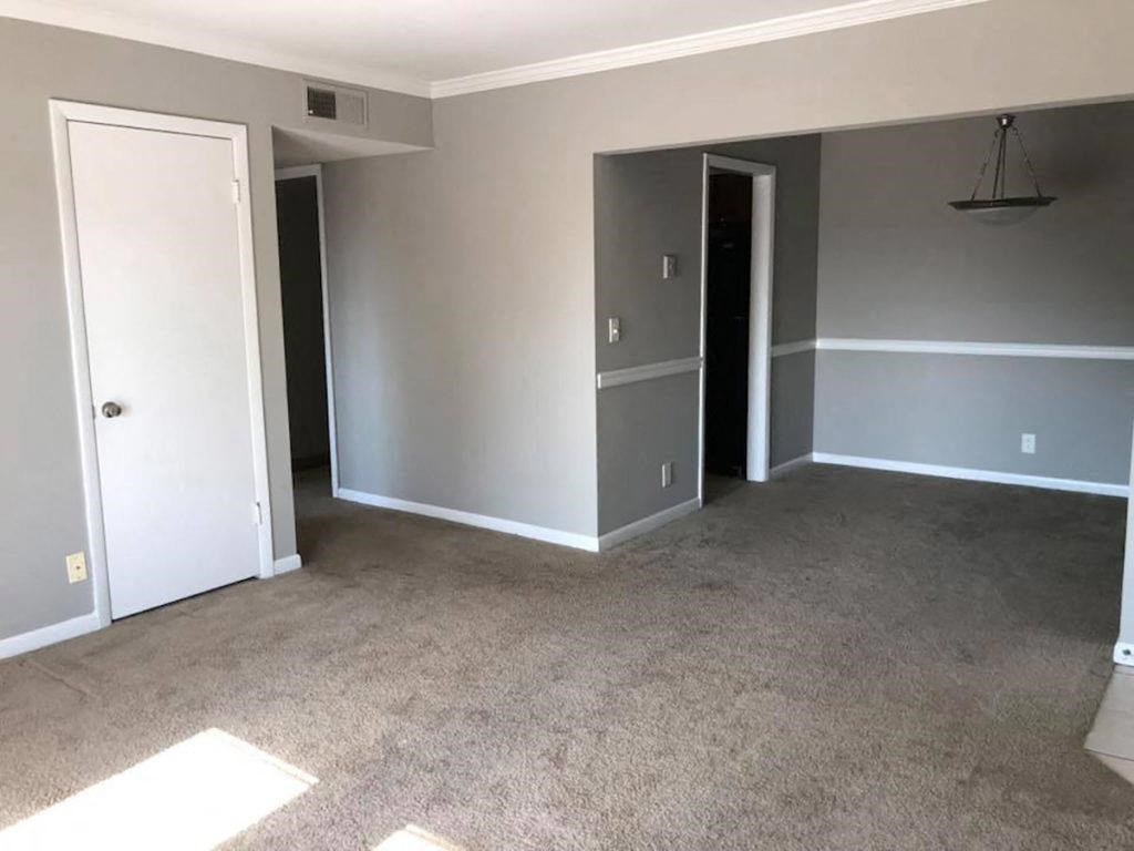 an empty living room with gray walls and carpet