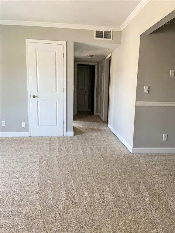 a hallway with a white door and a carpeted floor