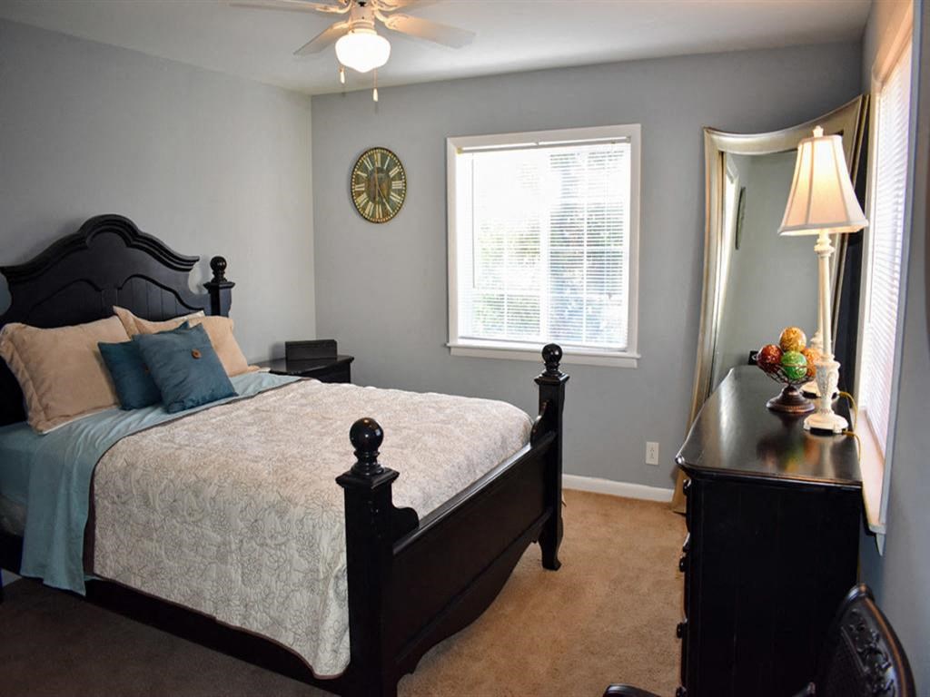a bedroom with a bed and a dresser and a window