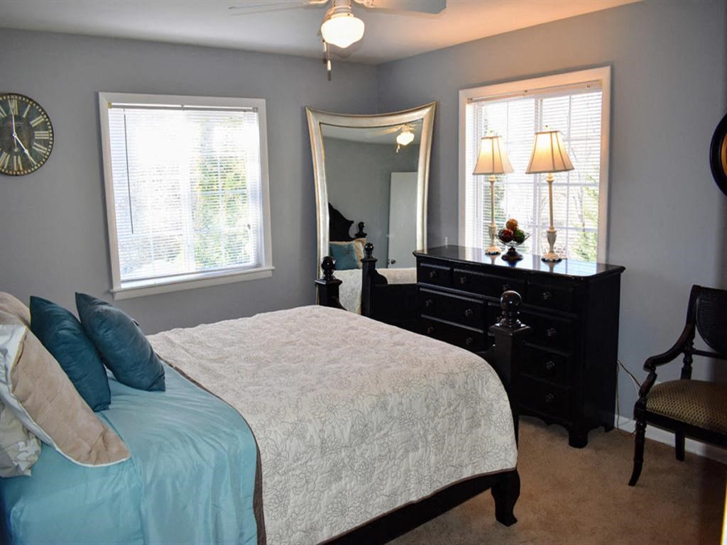 a bedroom with a bed and a dresser and a mirror