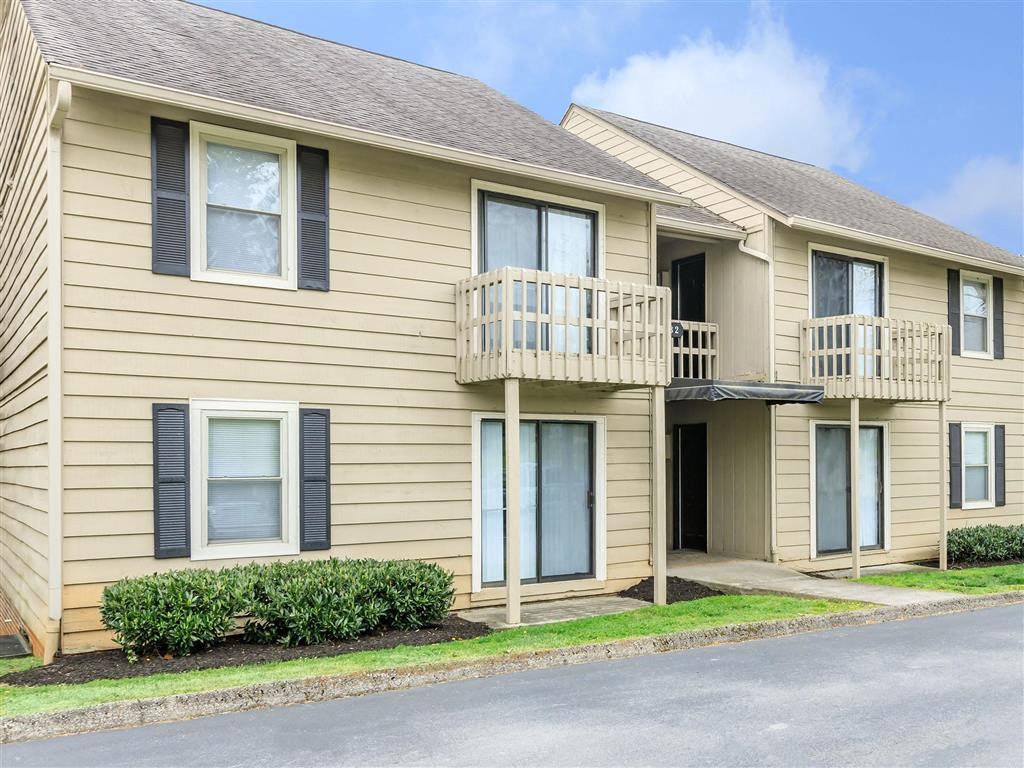 a yellow house with a balcony and a street in front of it