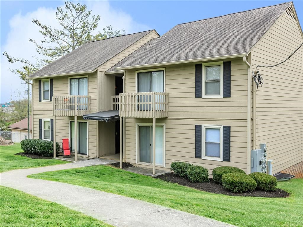 a tan house with a balcony and a sidewalk