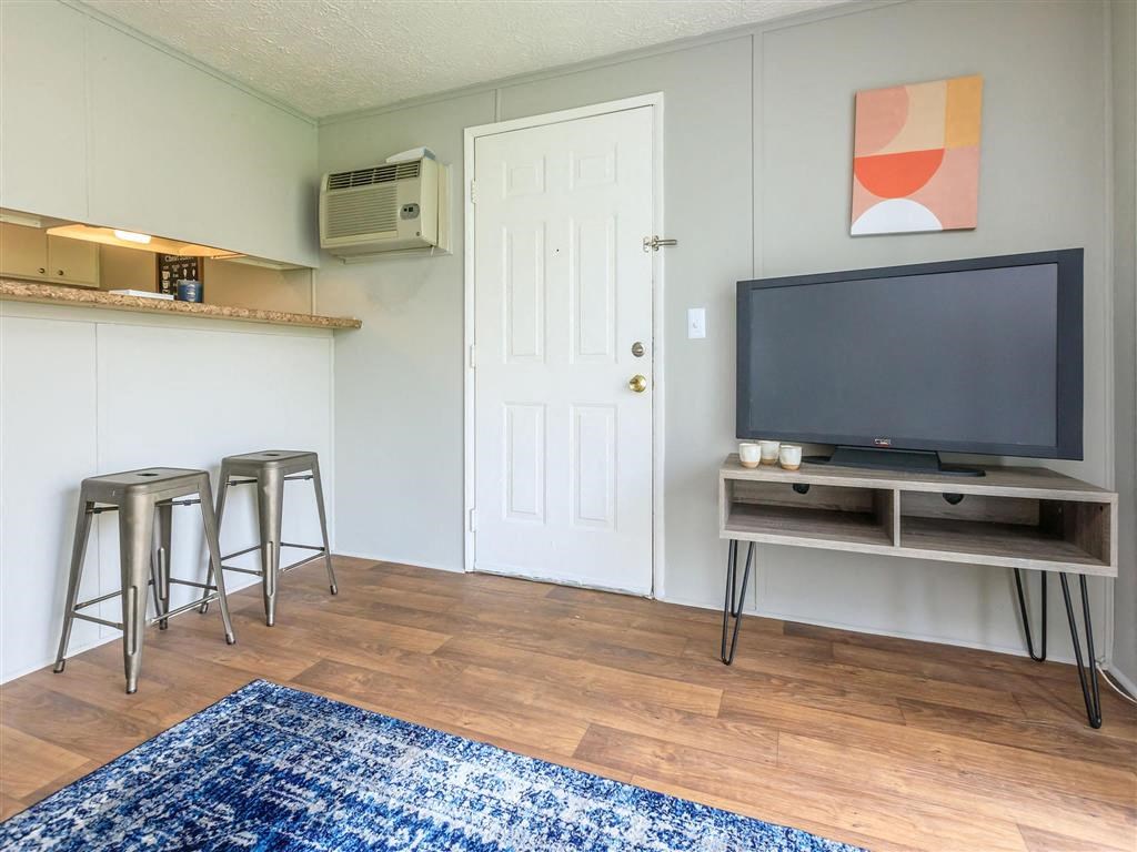 a living room with a television and bar stools