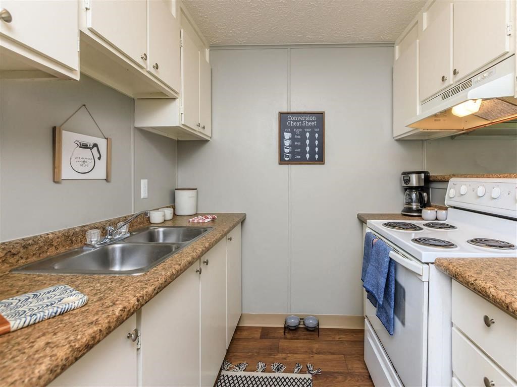 a kitchen with white appliances and counter tops and a sink