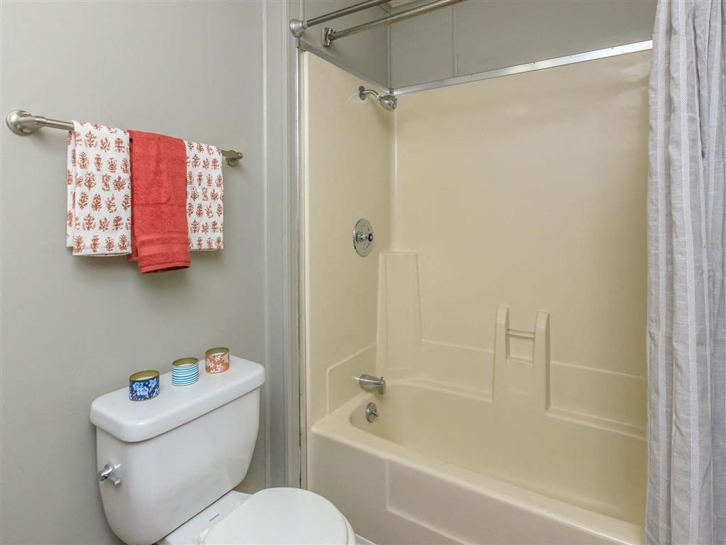 a white bathroom with a toilet and a shower