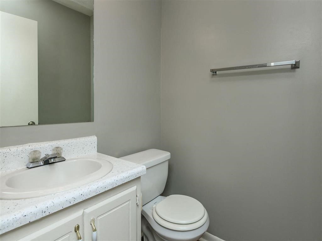 a bathroom with a toilet sink and a mirror