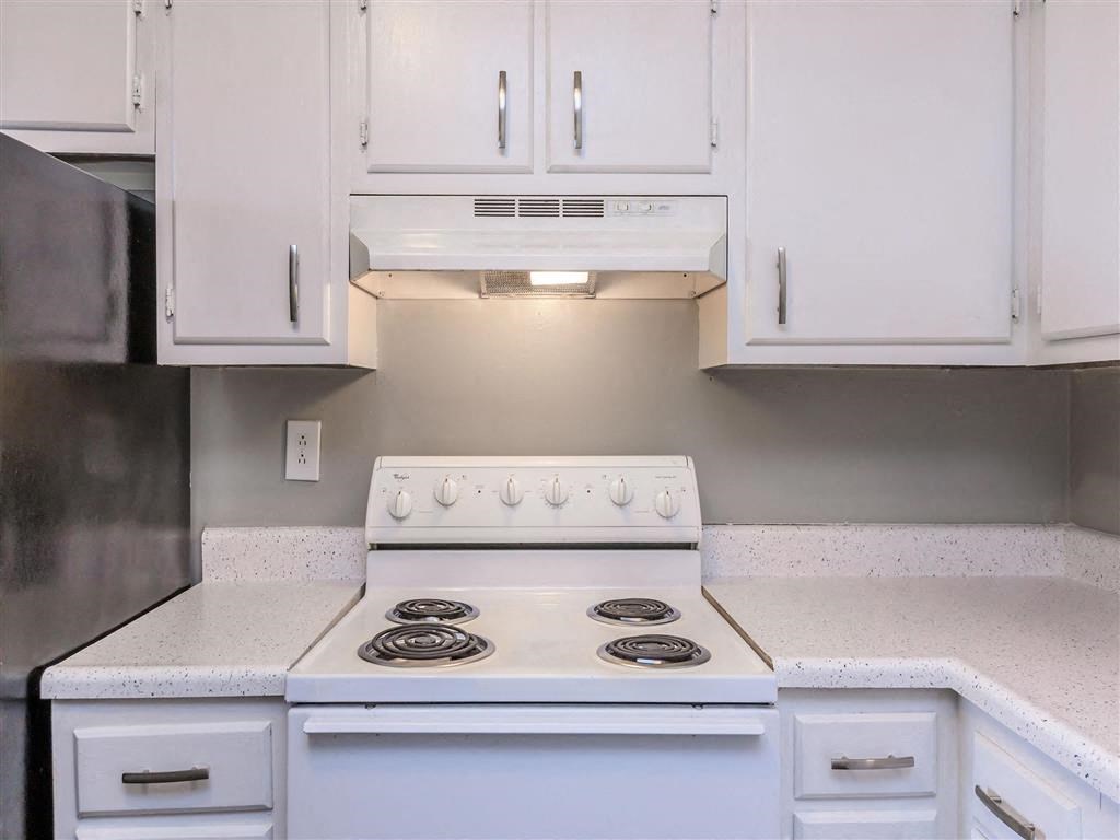 a kitchen with white cabinets and a white stove