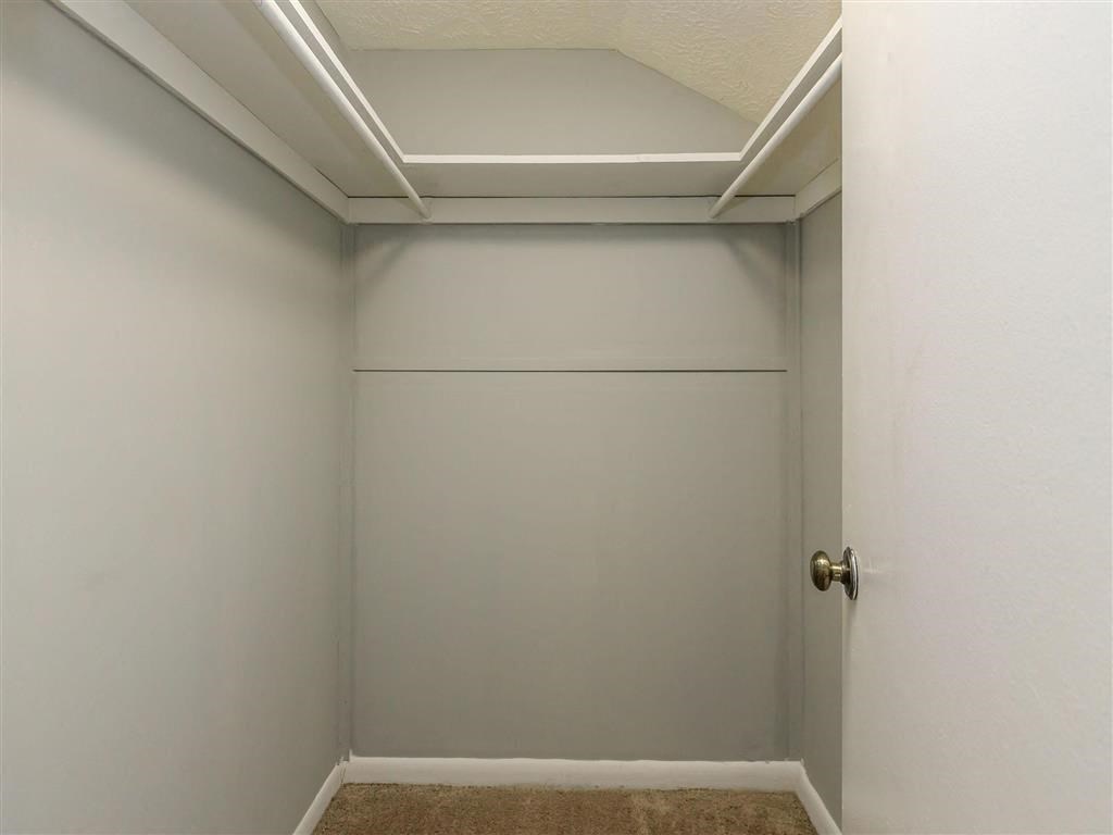 a white closet with a door and a white wall